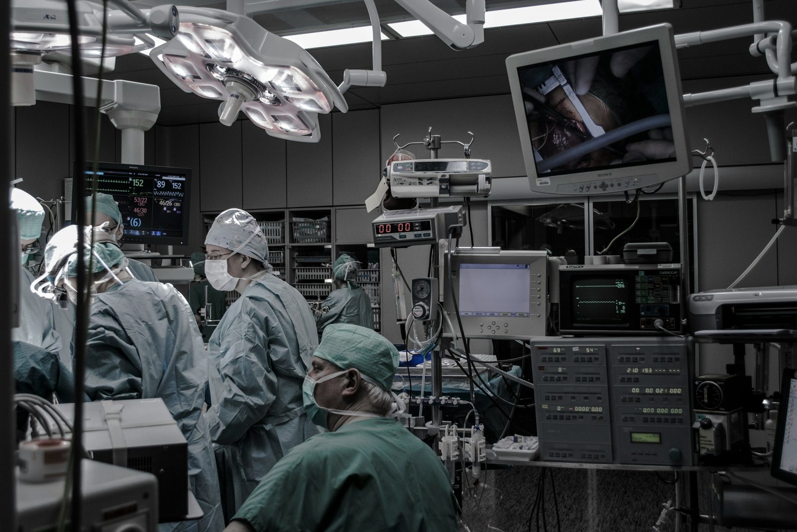 Surgical team in gowns, caps and masks working in a hospital operating room