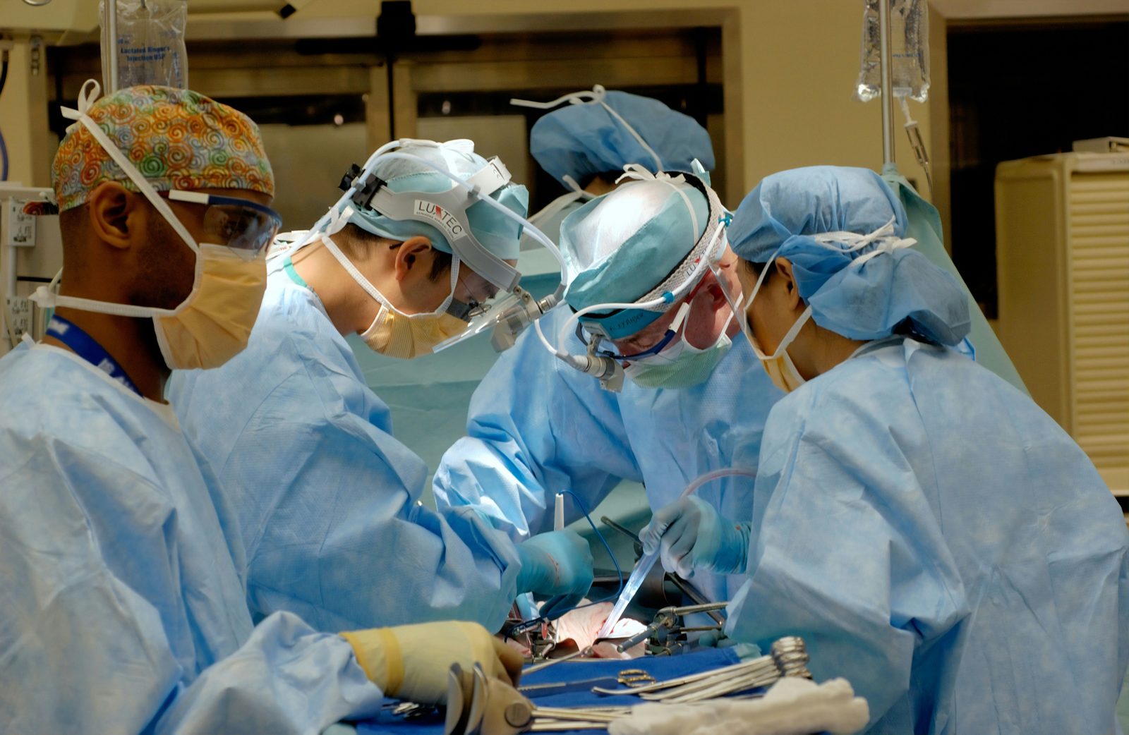 Surgical team in disposable gowns, caps and masks in an operating room