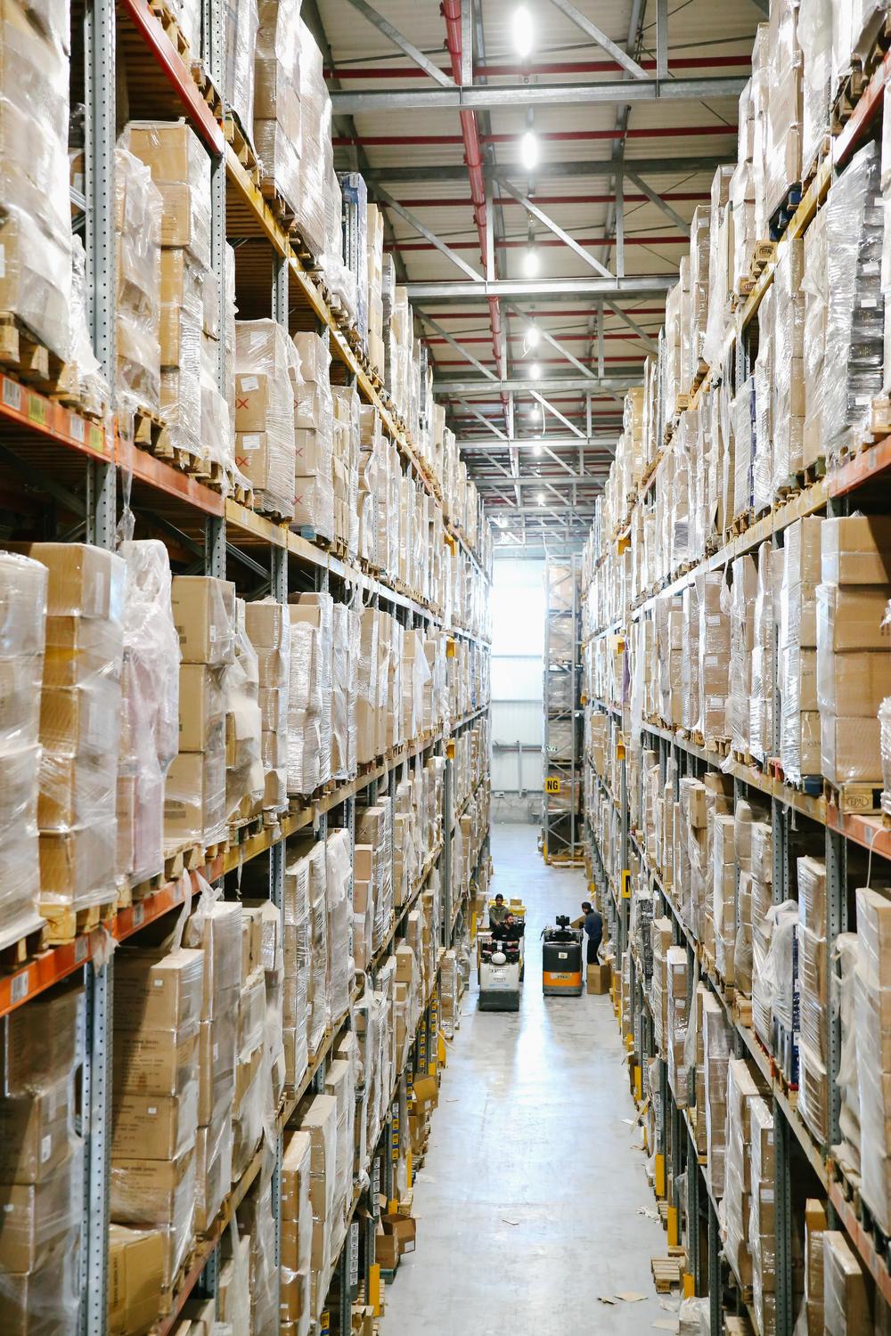 Warehouse aisle with pallets of cartons stacked high on racking